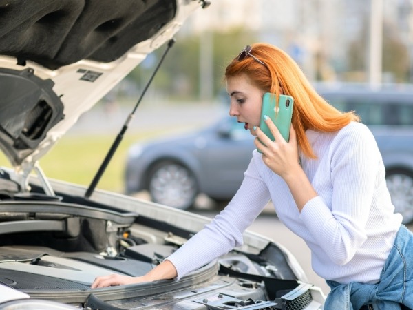 Woman Checking a Broken Car